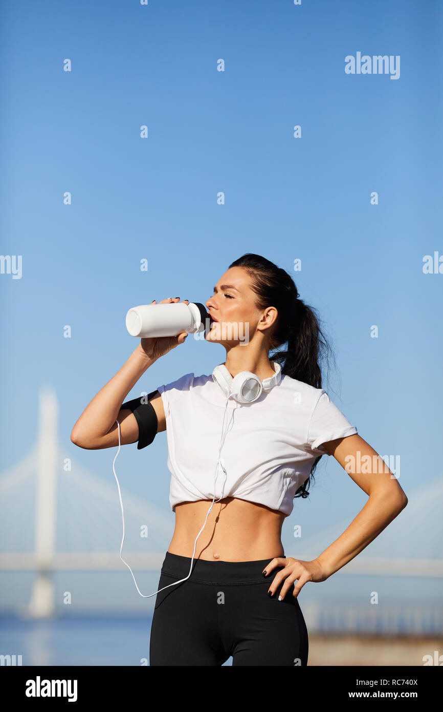 Sportliche Dame Trinkwasser aus der Flasche Stockfoto