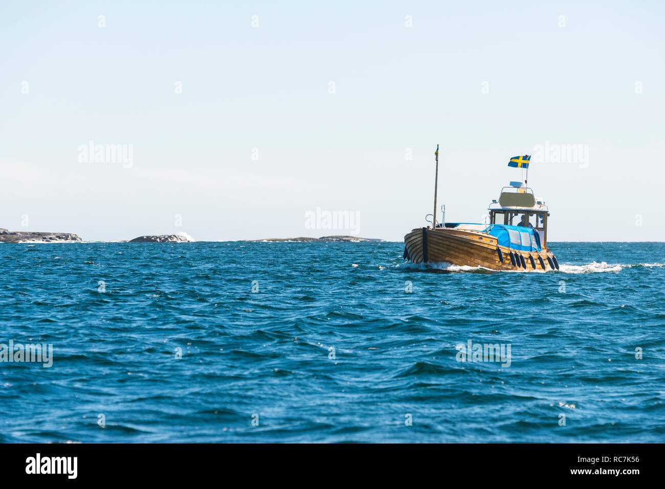 Trawler mit schwedischer Flagge auf Meer Stockfoto