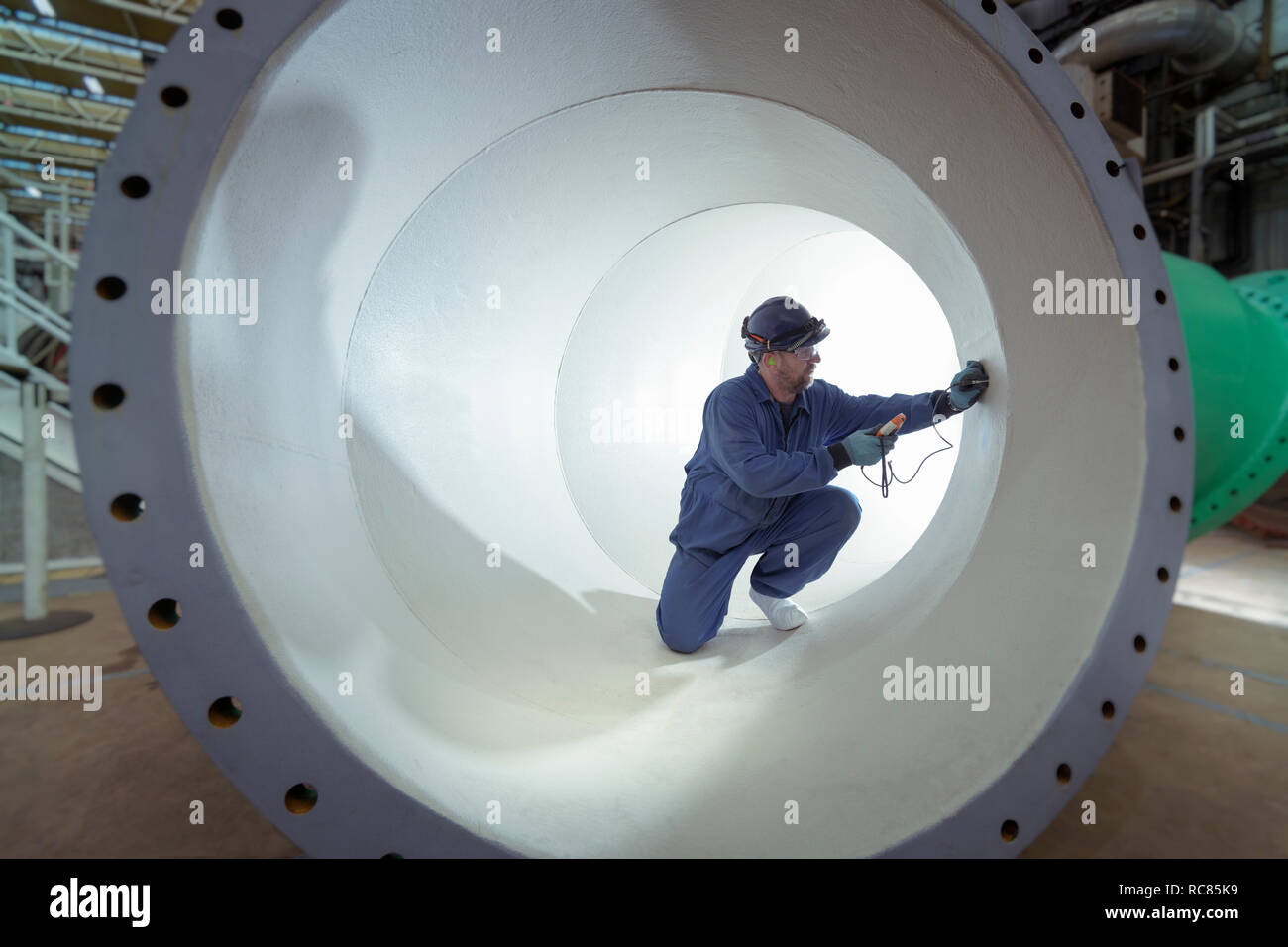 Prüfung Schutzlack in großen Rohr in der Turbine Hall der Kernkraftwerk Stockfoto
