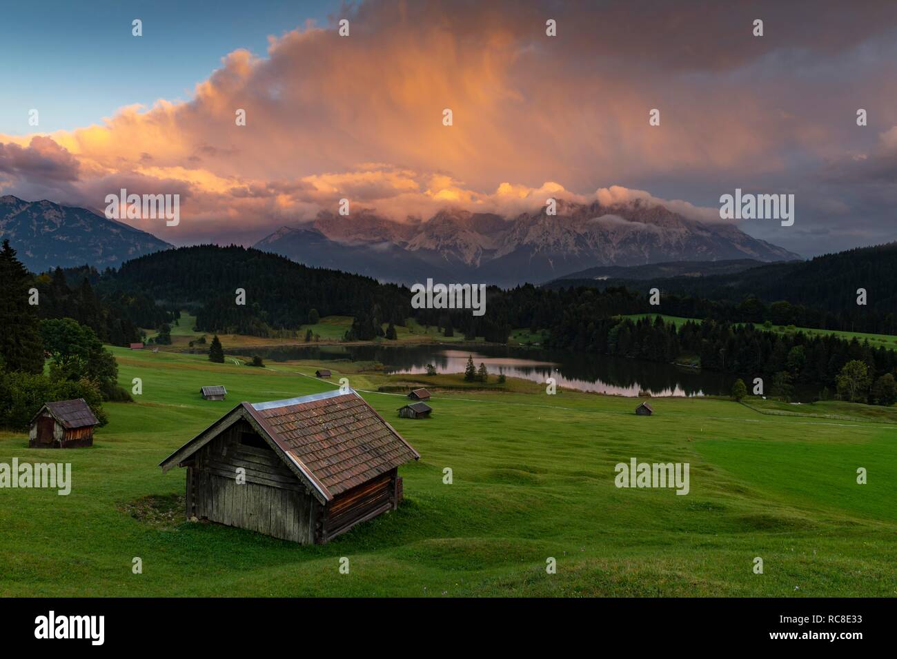 Kleine Hütte auf der Bergwiese mit Geroldsee, im Hintergrund das Karwendelgebirge mit dramatischen Wolke Himmel, Gerold, Mittenwald Stockfoto