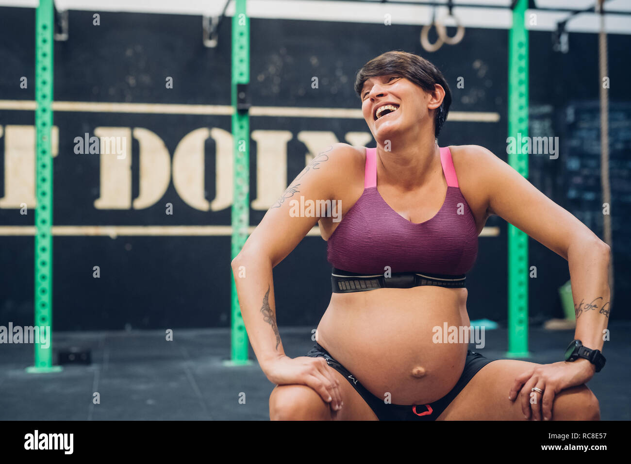 Schwangere Frau in der Turnhalle lachen Stockfoto