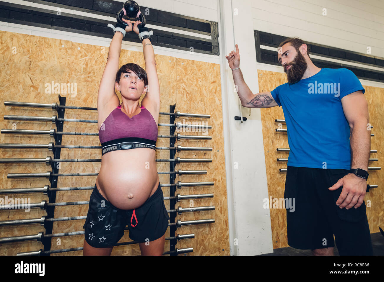 Schwangere Frau mit kettlebell in der Turnhalle Stockfoto