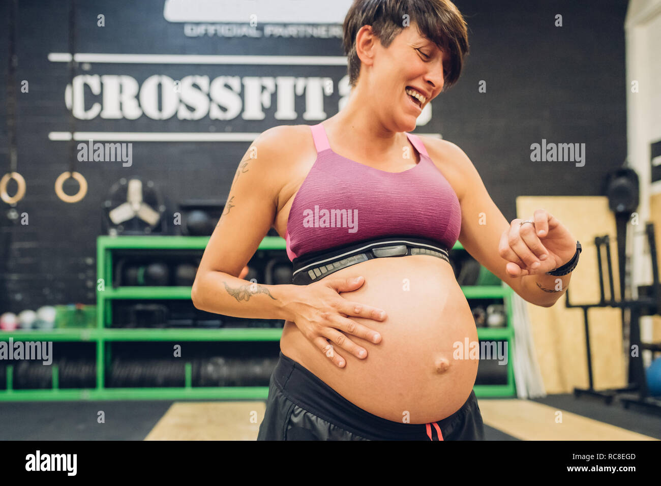 Schwangere Frau zur Zeit in der Turnhalle auf der Suche Stockfoto