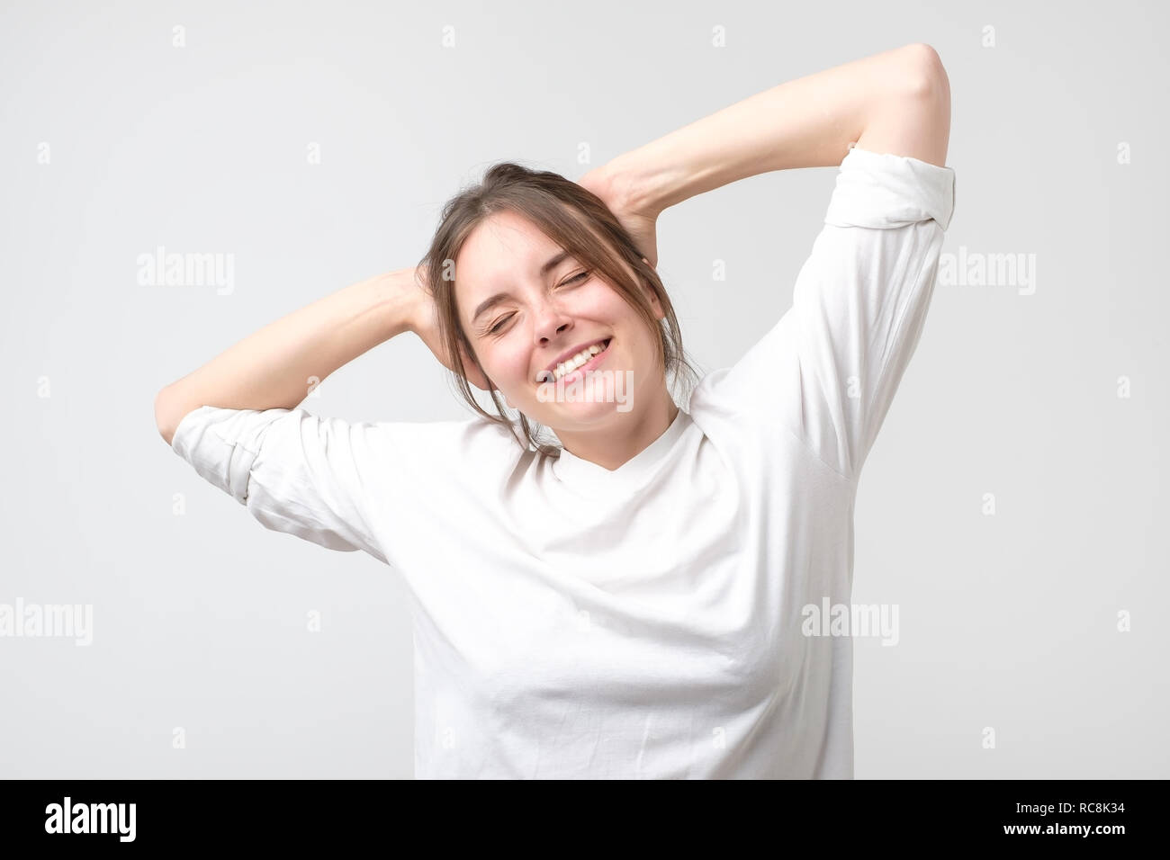 Junge schöne kaukasischen Lady in White's t-hirt Stretching nach dem Erwachen. In einem guten Schlaf Stockfoto