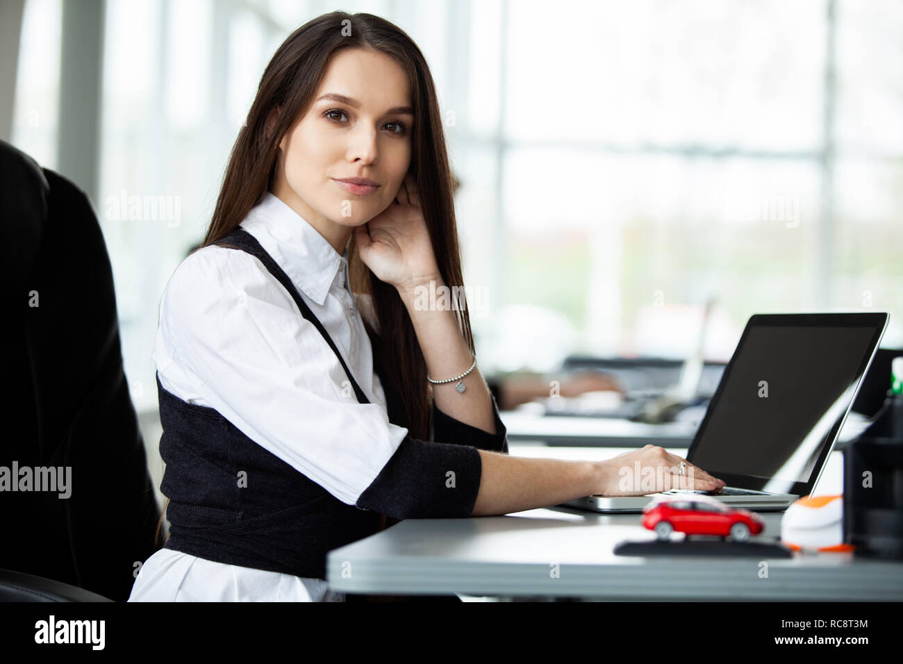 Portrait Of Happy and Geschäftsfrau, die an ihrem Arbeitsplatz im Büro zu sitzen. Stockfoto