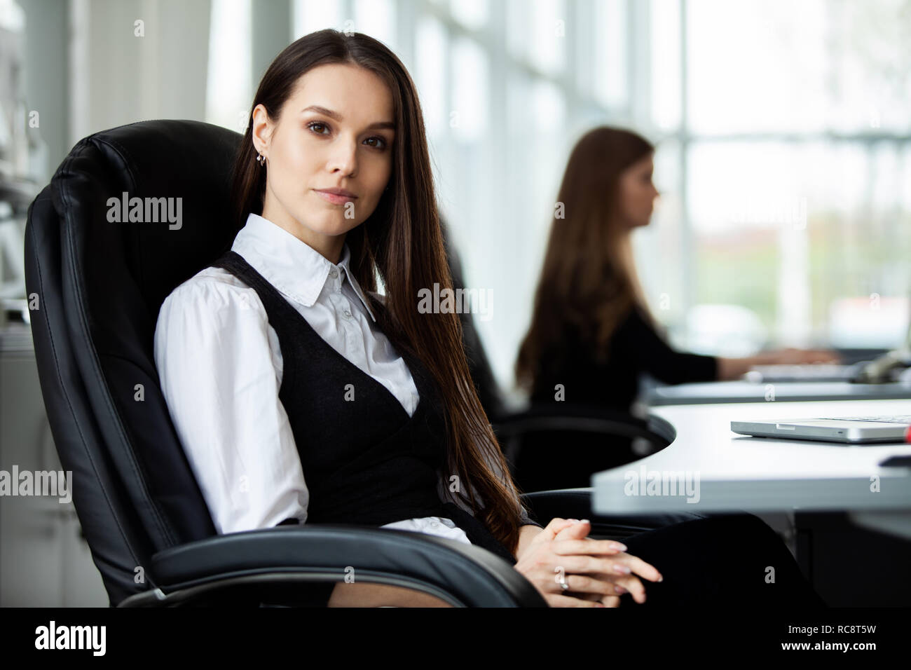 Portrait Of Happy and Geschäftsfrau, die an ihrem Arbeitsplatz im Büro zu sitzen. Stockfoto