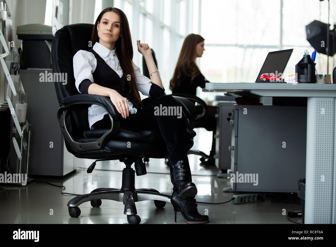 Portrait Of Happy and Geschäftsfrau, die an ihrem Arbeitsplatz im Büro zu sitzen. Stockfoto