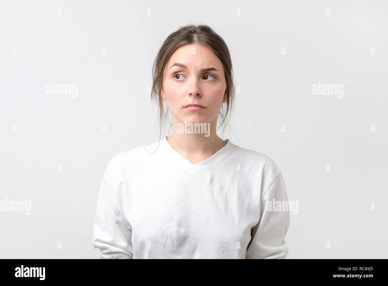 Zweifelnd Frau suchen mit Unglauben Ausdruck beiseite. Junge emotionale Frau vermuten, dass Ihr Mann oder Freund im Betrug. Stockfoto