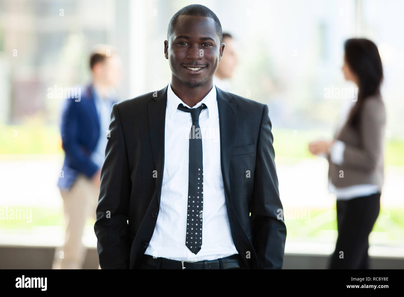 Schönen afrikanischen Geschäftsmann mit einer Gruppe von Geschäftsleuten für den Hintergrund. Stockfoto