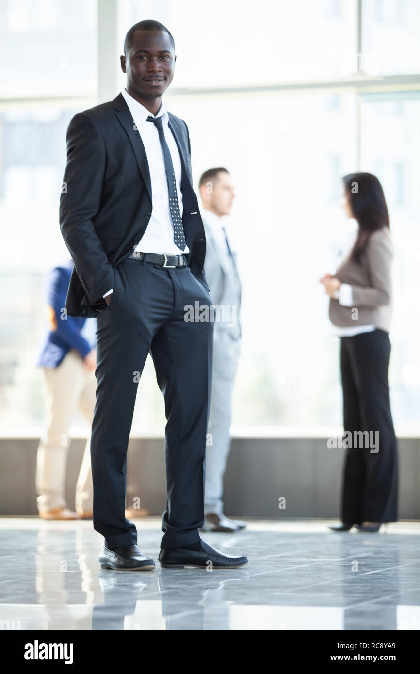 Schönen afrikanischen Geschäftsmann mit einer Gruppe von Geschäftsleuten für den Hintergrund. Stockfoto