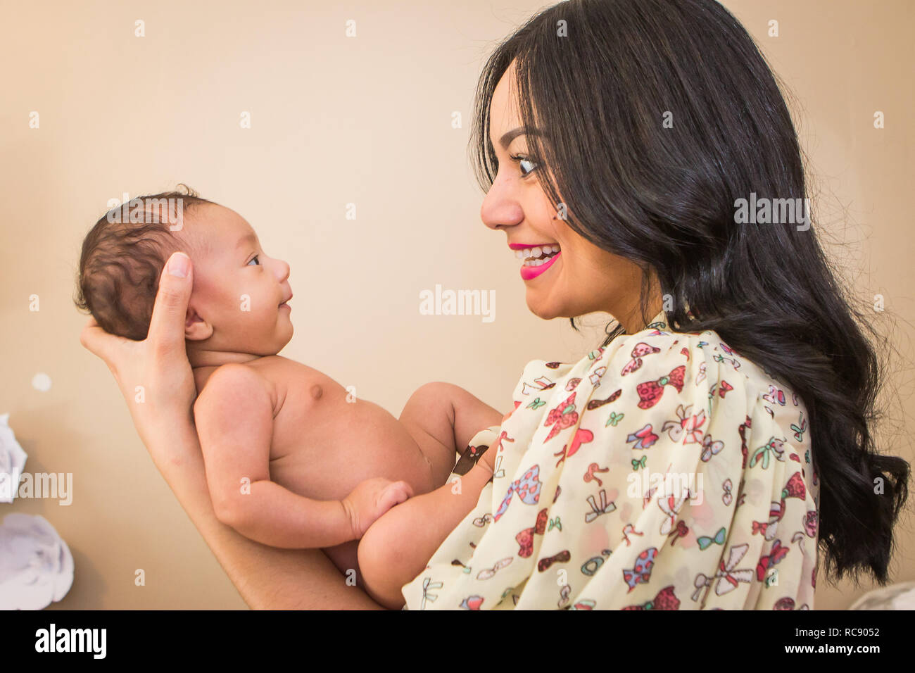 Hispanic junge Mutter lächelnd mit neugeborenen Babys Stockfoto