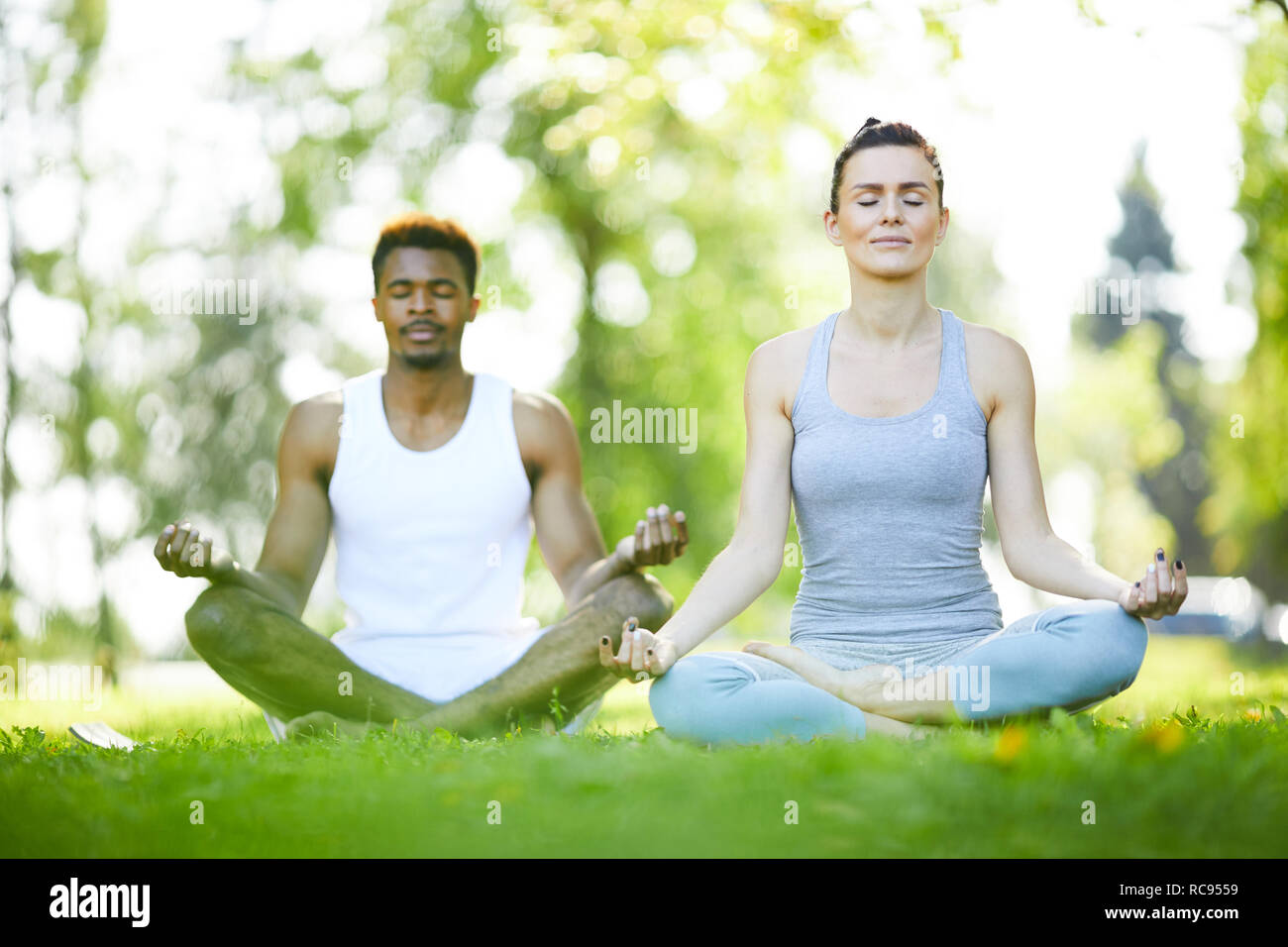 Junger Mann und Frau praktizieren Yoga im Freien Stockfoto