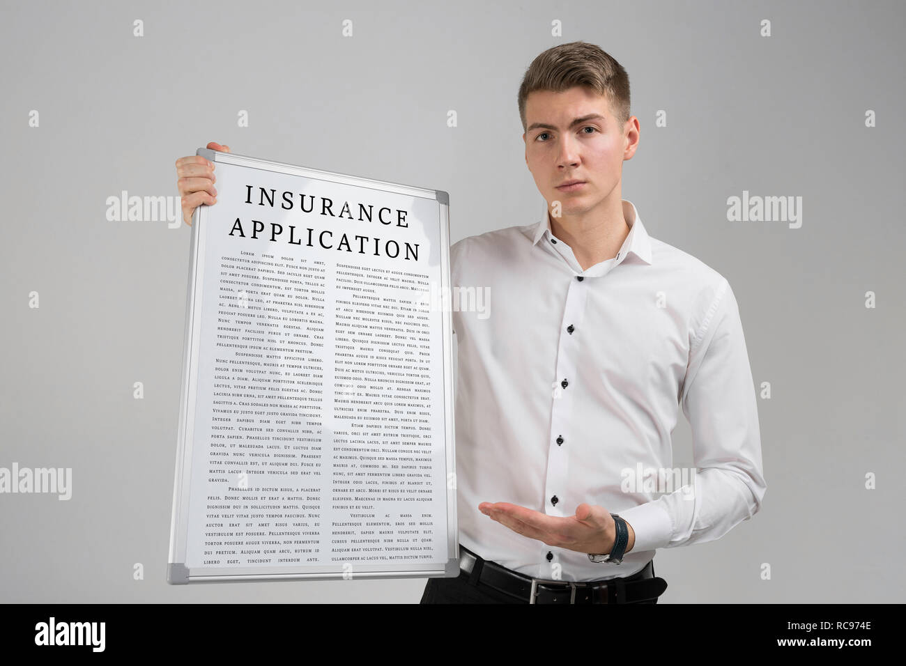 Junge Mann hält in der Hand einen Antrag für die Versicherung vor einem hellen Hintergrund isoliert ist. Stockfoto