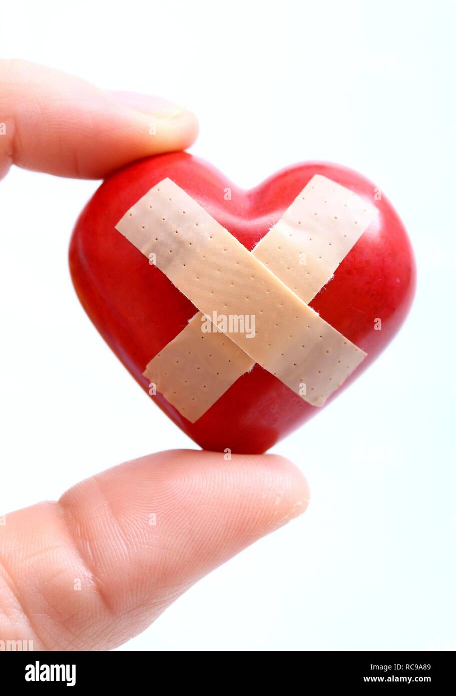Hand Halt Ein Rotes Herz Mit Einem Pflaster Symbolische Bild Fur Herzkrankheit Herzinfarkt Einem Kranken Herzen Stockfotografie Alamy