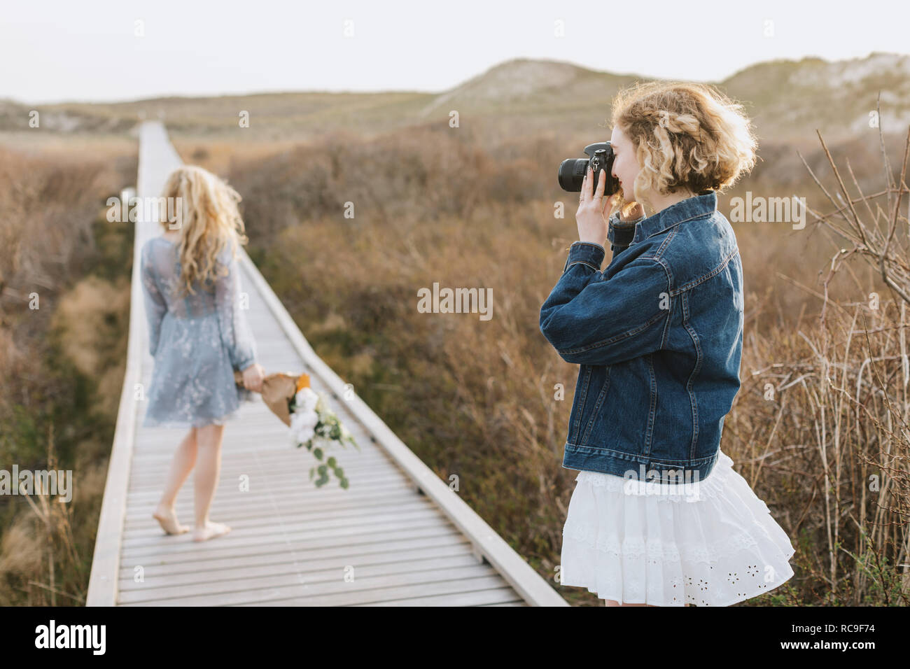 Junge Frau fotografieren Freund auf Coastal dune Promenade, Menemsha, Martha's Vineyard, Massachusetts, USA Stockfoto