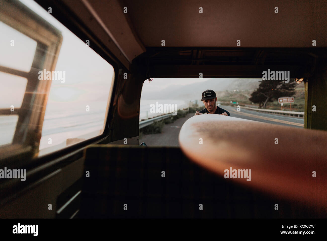 Mann auf Van road trip laden Surfboard, Ventura, Kalifornien, USA Stockfoto