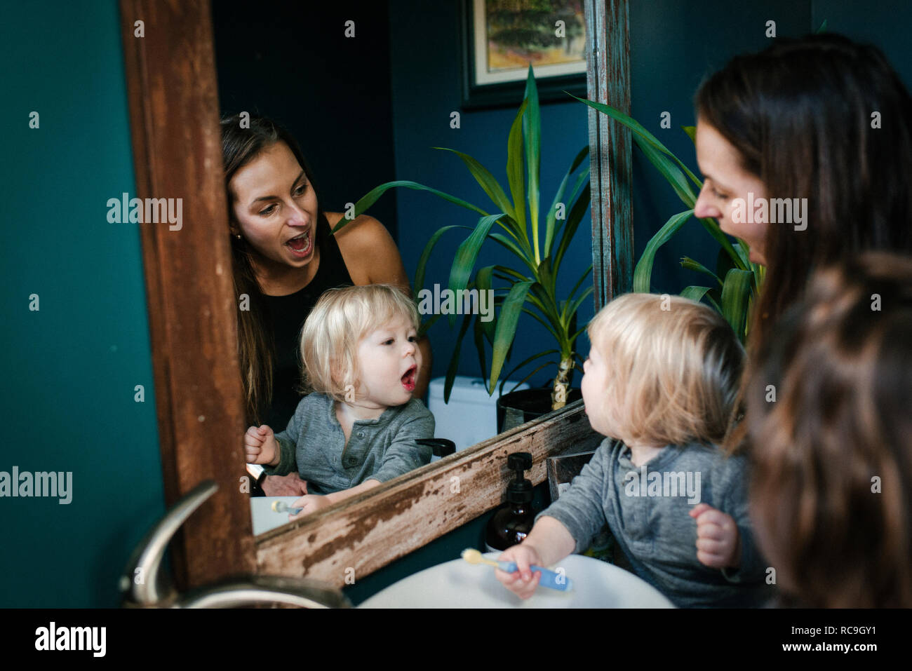 Mutter und Sohn in einen Spiegel, mit offenem Mund auf der Suche Stockfoto