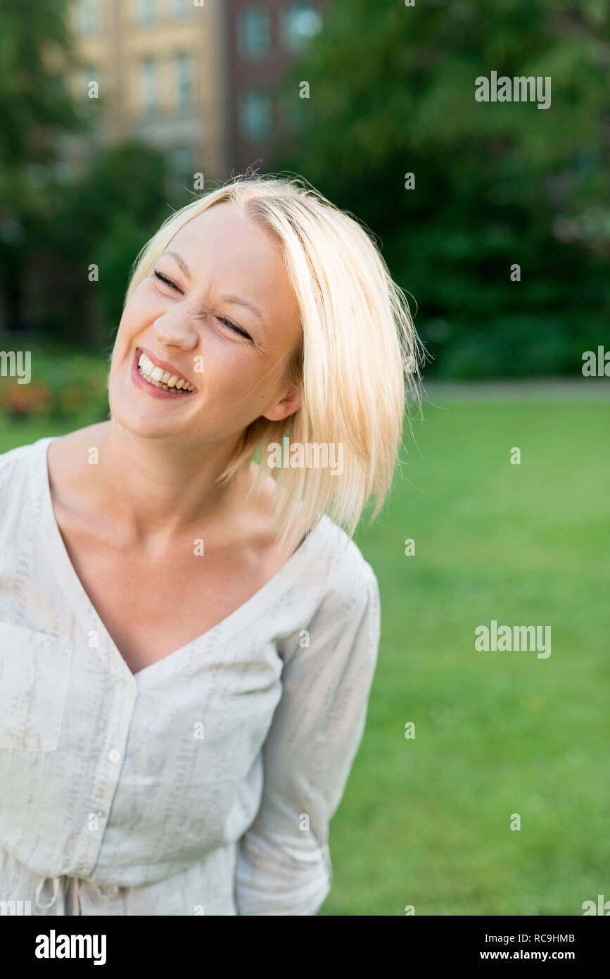 Junge Frau Lachen im park Stockfoto