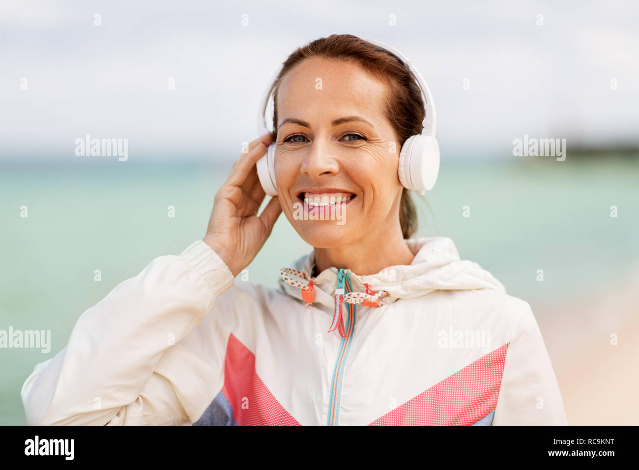 Frau mit Kopfhörer Musik hören am Strand Stockfoto