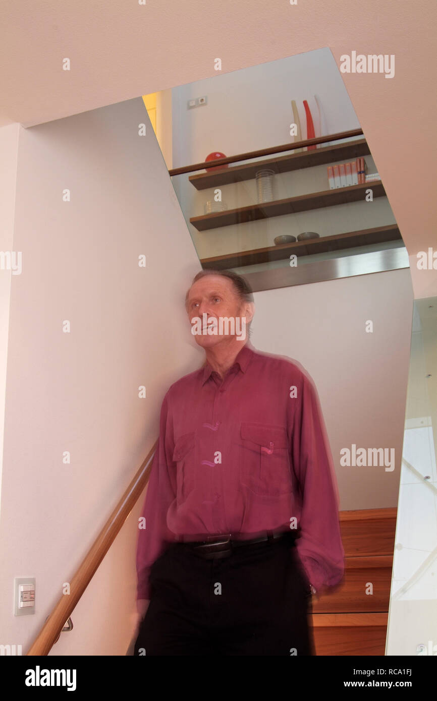 Mann mittleren Verändert e auf einer Treppe | Mann mittleren Alters steht auf einer Treppe Stockfoto