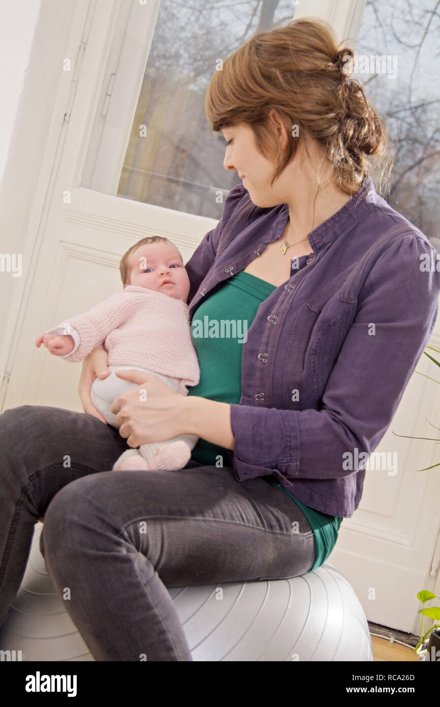 Junge Mutter hält ihre neugeborene Tochter im Arm, das Art ist 12 Tage alt | junge Mutter ihr neugeborenes Baby in ihren Armen halten - das Baby ist 12 Tag Stockfoto