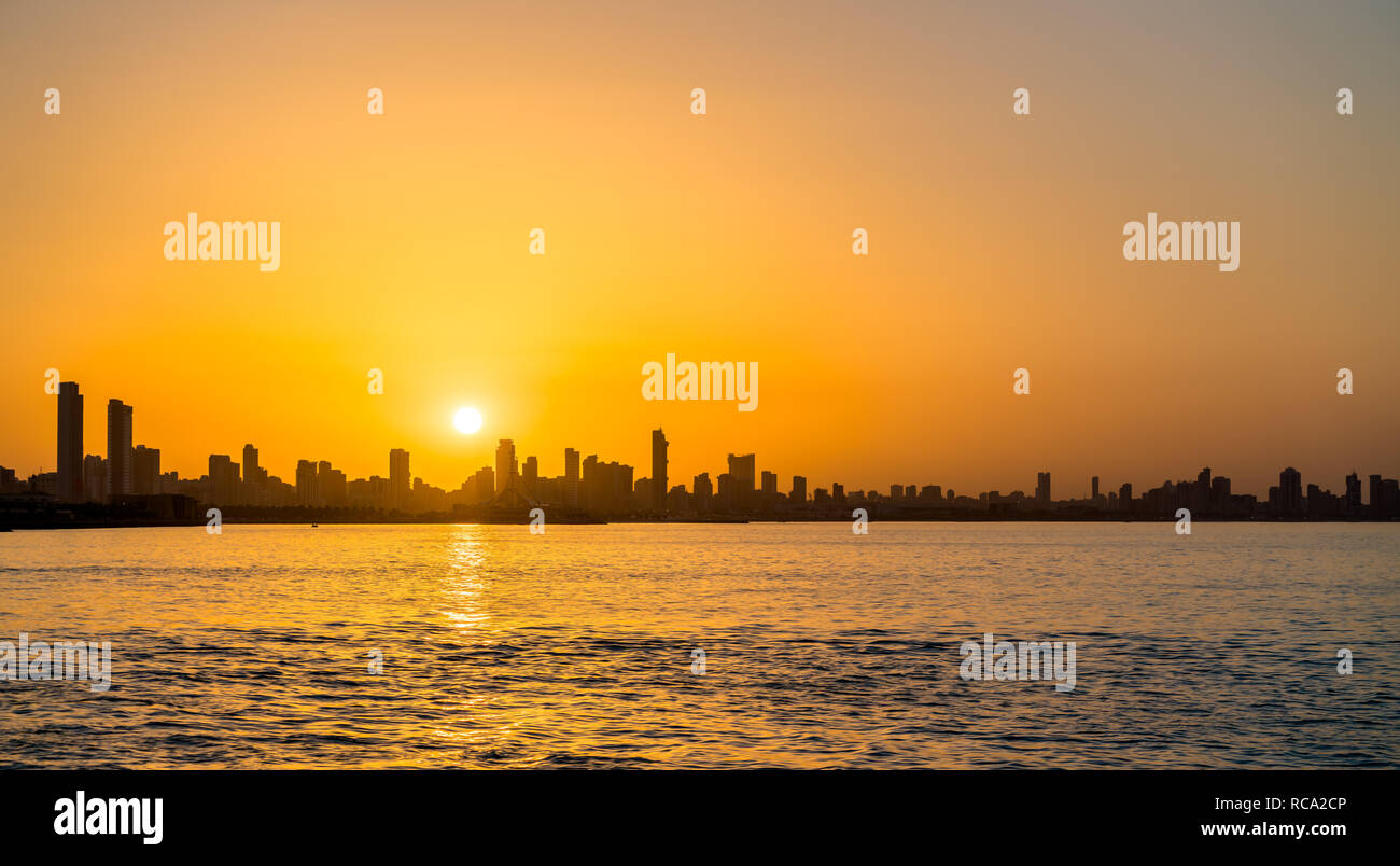 Skyline von Kuwait City bei Sonnenuntergang. Stockfoto