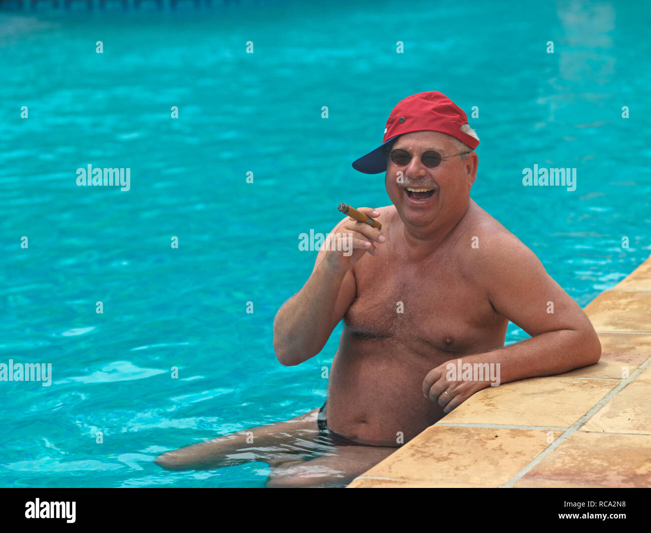 Älterer Mann mit Zigarre im Schwimmbad | älterer Mann rauchen eine Cigarre im Schwimmbad Stockfoto