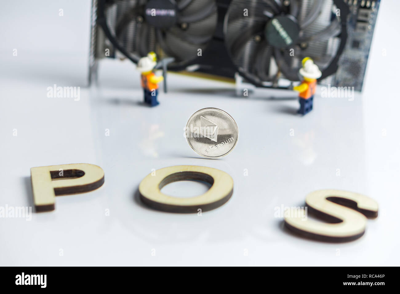 Des astraleums Cryptocurrency Umschalten von POW, GPU Bergbau, POS, POS-Schild mit Grafikkarte und Figuren im Hintergrund Stockfoto