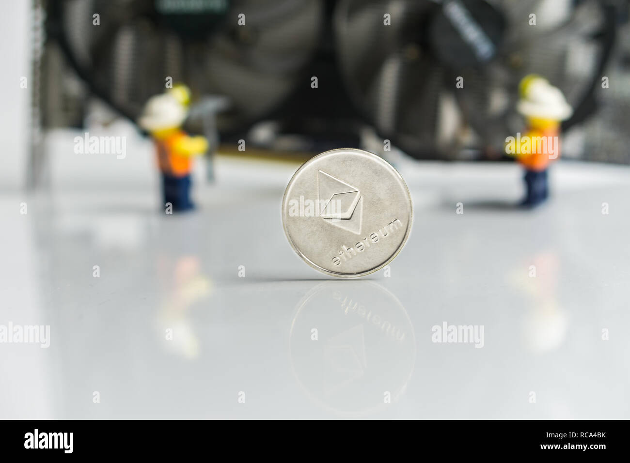 Des astraleums Cryptocurrency Umschalten von POW, GPU Bergbau, POS, POS-Schild mit Grafikkarte und Figuren im Hintergrund Stockfoto