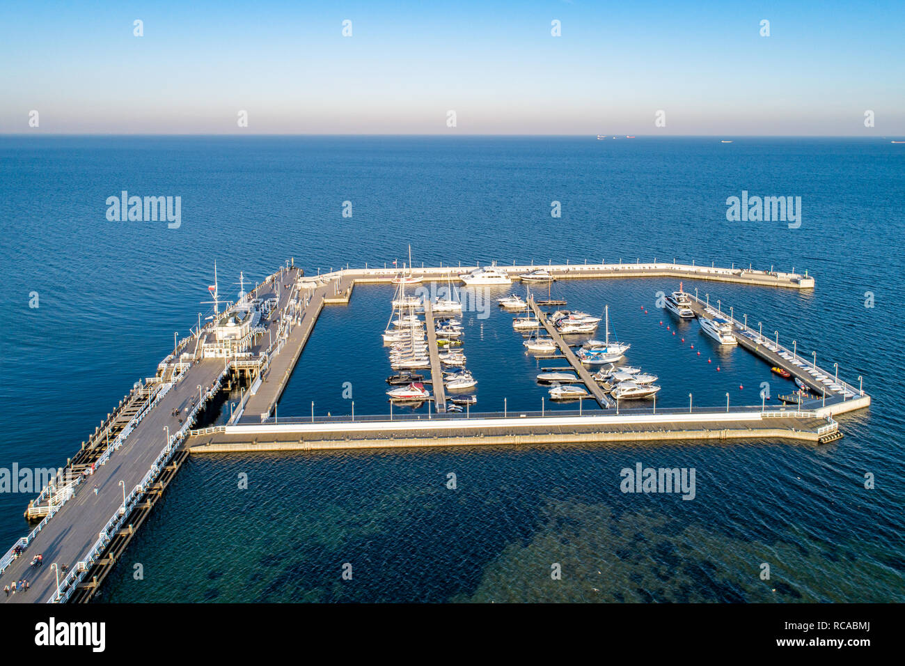 Hölzerne Seebrücke, genannt Molo, mit Hafen und Jachthafen mit Yachten in Sopot Resort in der Nähe von Danzig in Polen im Abendlicht. Luftaufnahme. Stockfoto