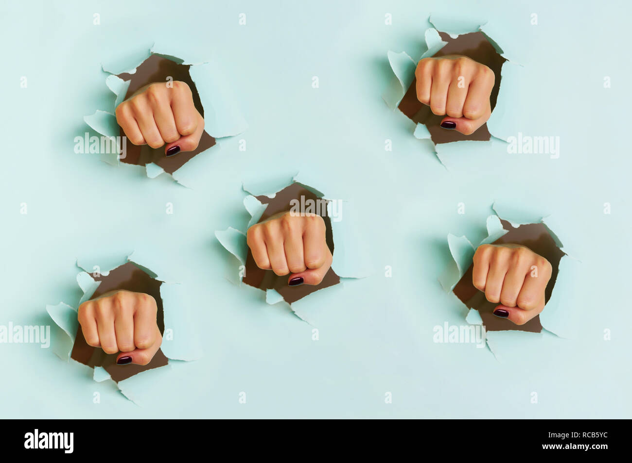 Chaotischen Muster der weiblichen Fäuste Stanzen durch blauen Hintergrund. Krieg, Kampf, Konflikt, feministischen Konzept. Banner mit kopieren. Stockfoto