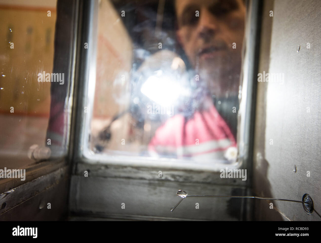 Mainz, Deutschland. 18 Dez, 2018. Miklos Szakall, Leiter der Windkanal Labor an der Universität Mainz, beobachtet die Bildung eines Tropfen im Windkanal. In einem Windkanal - wie experimentelle Aufbau an der Universität Mainz, das Verhalten von Cloud Partikel wie Wassertropfen, Graupel oder Hagel ist unter dem Einfluss von verschiedenen Temperaturen und Windgeschwindigkeiten untersucht. (Dpa vom 15.01.2019: 'Microscope in den Wolken' - einzigartige Windkanal in Mainz) Credit: Andreas Arnold/dpa/Alamy leben Nachrichten Stockfoto