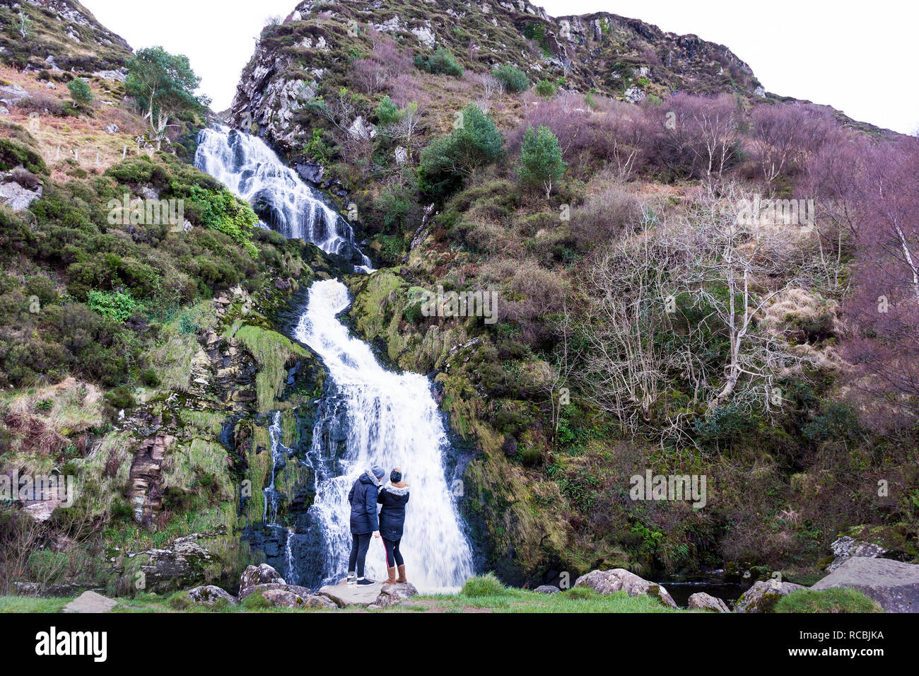 Assaranca Wasserfall, Maghera, County Donegal, Irland. 15. Januar 2019. Menschen besuchen den berühmten Wasserfall auch an einem regnerischen Tag im Winter. Der Name "Assaranca" heißt übersetzt "Wasserfall der Grossen Ratte'. Credit: Richard Wayman/Alamy leben Nachrichten Stockfoto