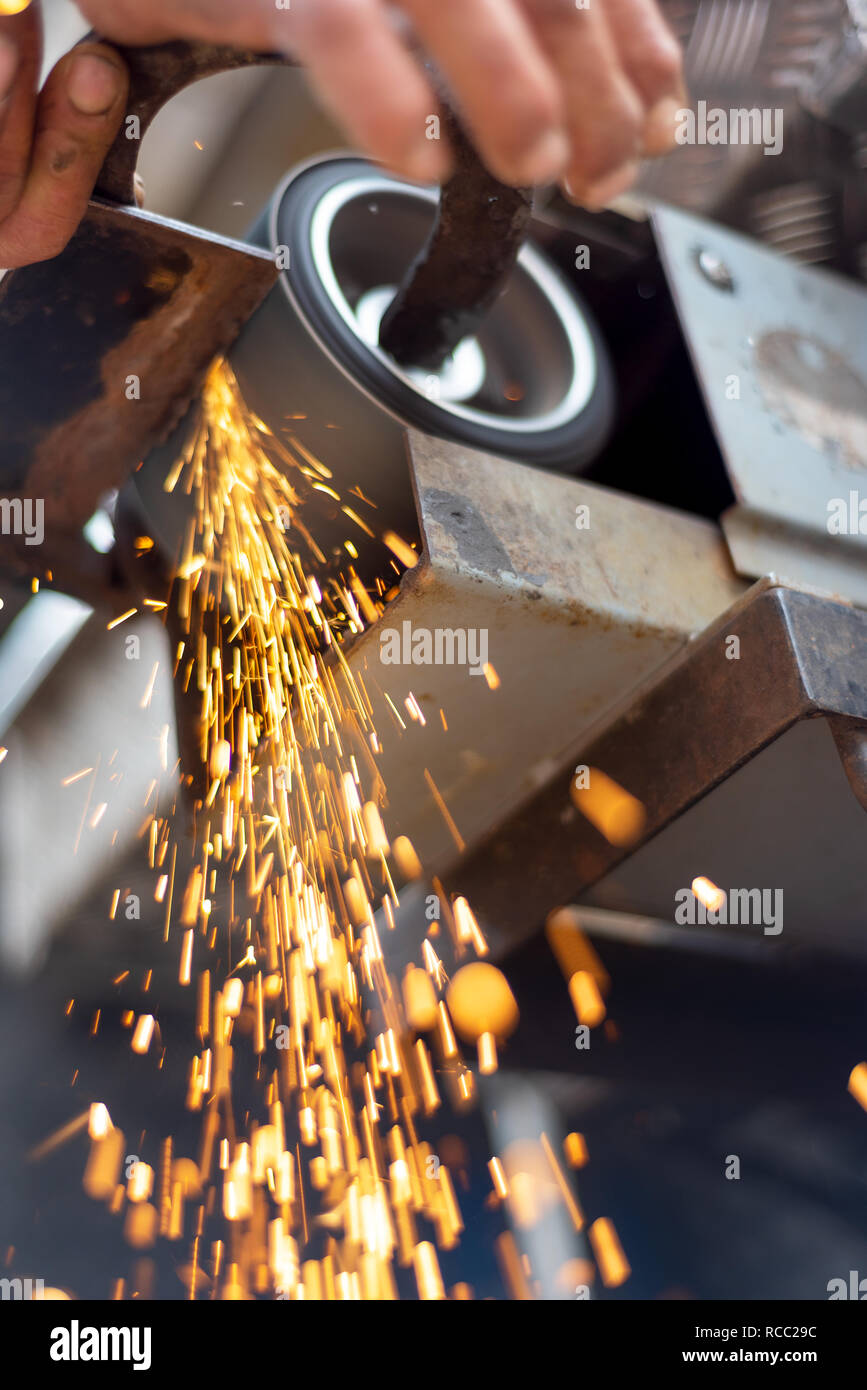 Metallverarbeitende Industrie: Finishing Metallbearbeitung auf horizontalen Oberflächen grinder Maschine mit Funkenflug. Stockfoto