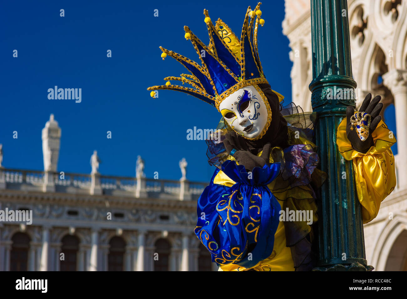 Karneval in Venedig. Eine wunderschöne venezianische Maske mit Jester's Cap vor dem Dogenpalast Stockfoto