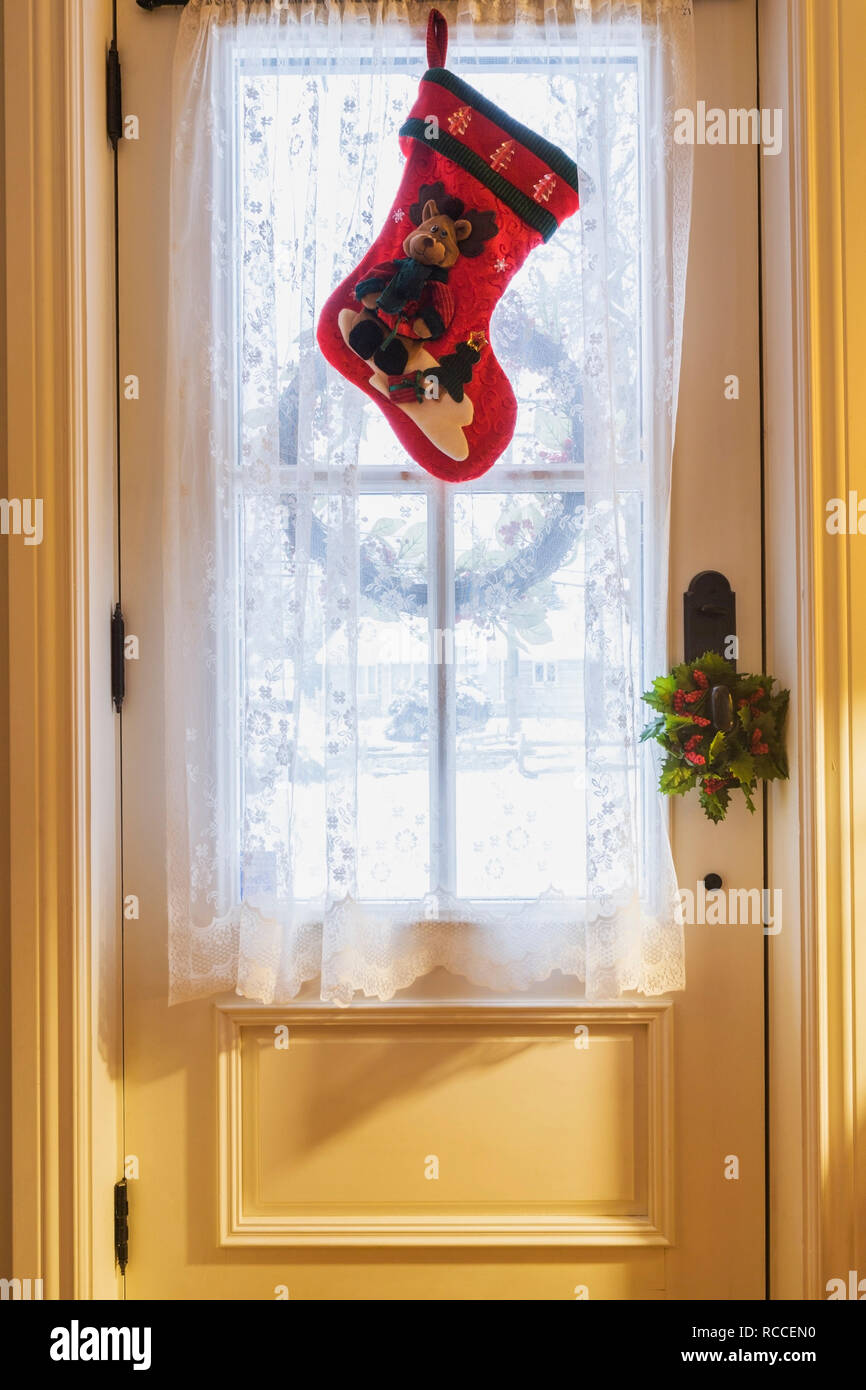 Rot und Grün Weihnachtsstrumpf über der Eingangstür innerhalb eines alten ca. 1886 Canadiana cottage Style home Hung Stockfoto