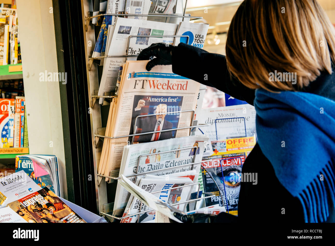 PARIS, Frankreich, 21.JANUAR 2017: Frau Kauf bei Media Presse Kiosk der Financial Times Weekend Edition mit Donald Trump US-Präsident des America First Slogan ant Stockfoto