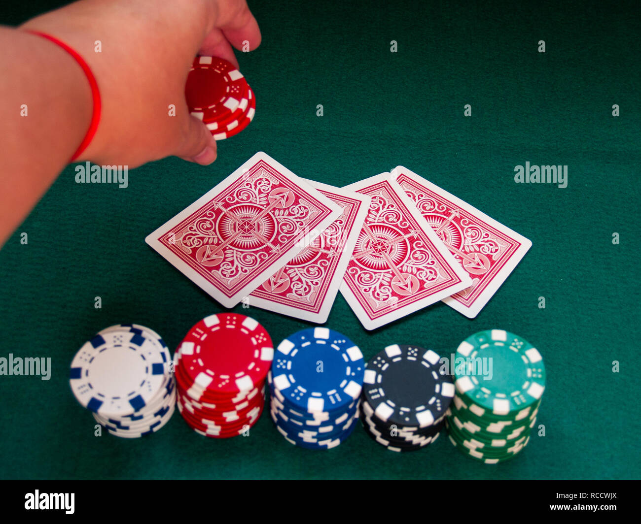 Eine Person spielen Poker Wetten poker chips in verschiedenen Farben Stockfoto