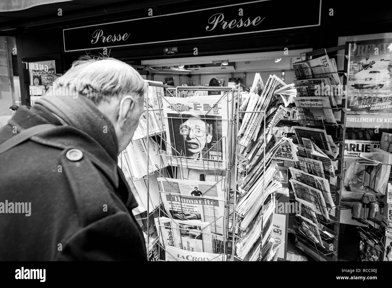 PARIS, Frankreich, 15. MÄRZ 2018: älterer Mann kaufen französische Zeitung Liberation an der Pariser Presse Kiosk mit Stephen Hawking portrait Schwarz und Weiß Stockfoto