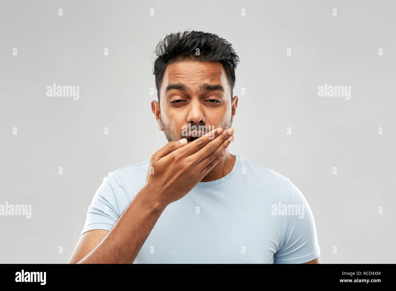 Müde inder Gähnen über grauer Hintergrund Stockfoto
