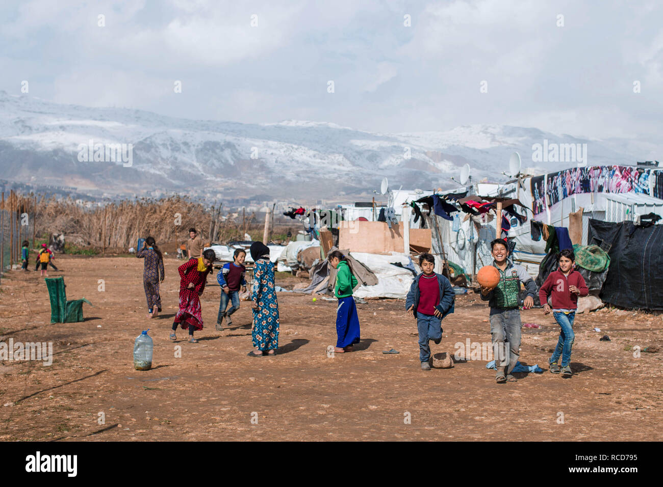 Da die Temperaturen sinken, Flüchtlinge vorbereiten für ein anderes nach den Schäden und Überschwemmungen durch Sturm Norma unleashed Sturm. Eine Familie beobachtete, wie Organisationen Beihilfen verteilen. Sturm Norma betroffen Tausende von syrischen Flüchtlinge leben in prekären Bedingungen in der Libanesischen Bekaa-tal. Sie sind jetzt gezwungen, die für eine andere Sturm, die sich vorbereitet werden. Stockfoto