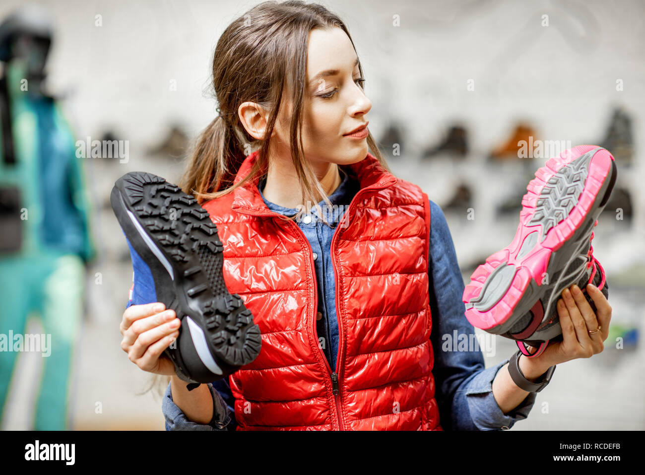 Junge Frau Wahl trail Schuhe für Wandern im modernen Sport Shop Stockfoto