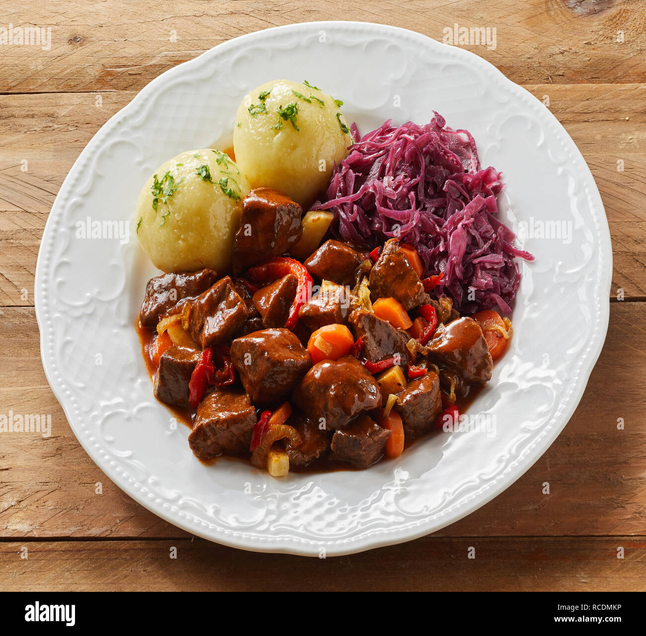 Platte von Rotwild oder Hirschgulasch mit geschredderten Rotkohl und Klöße für einen leckeren Deutschen oder Bayerischen Mahlzeit im quadratischen Format Stockfoto