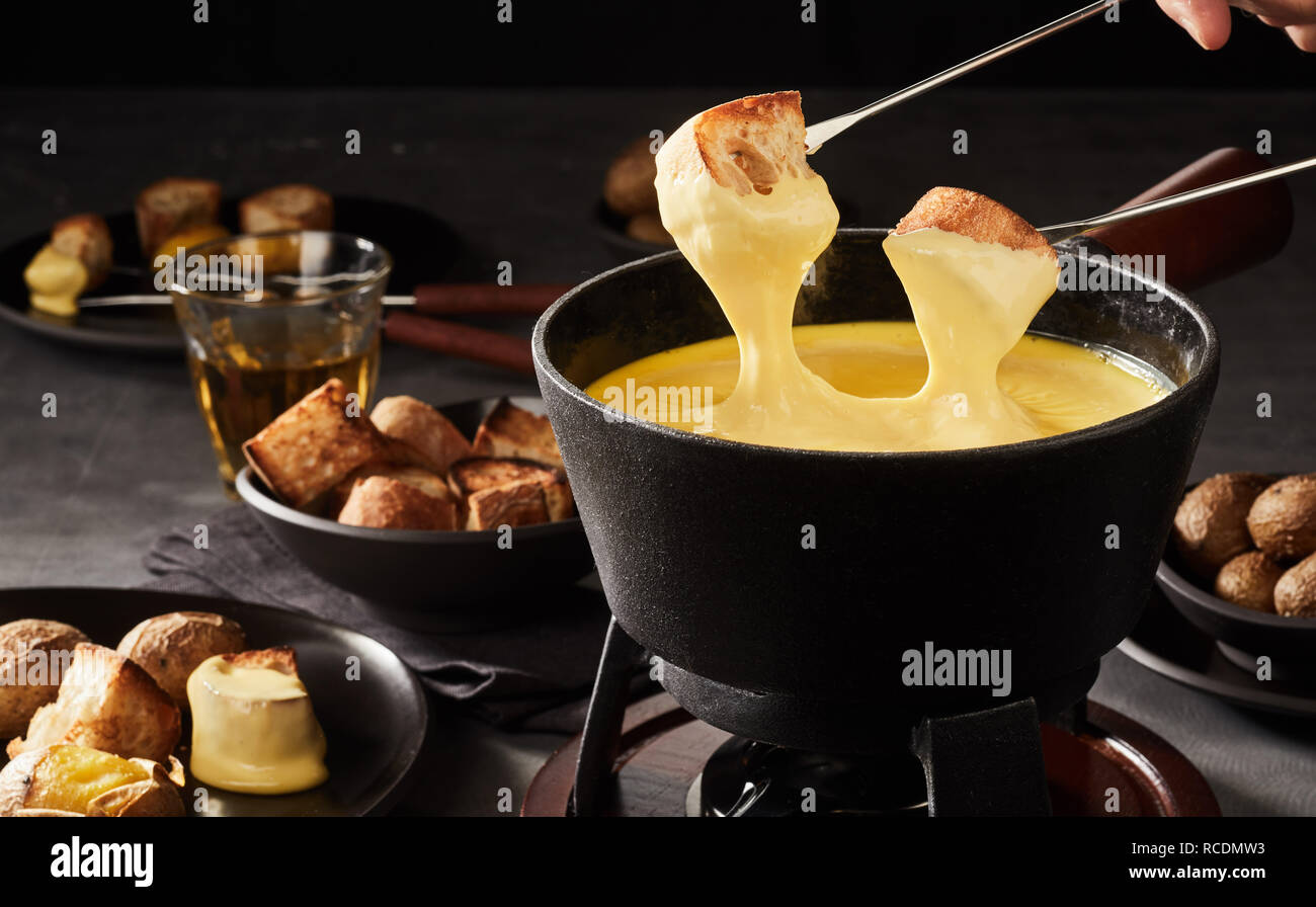 Tauchen Toast beschichtet in Sauce in einem Schweizer Käse Fondue mit  Begleitungen für Eintauchen in der Nähe zu sehen Stockfotografie - Alamy