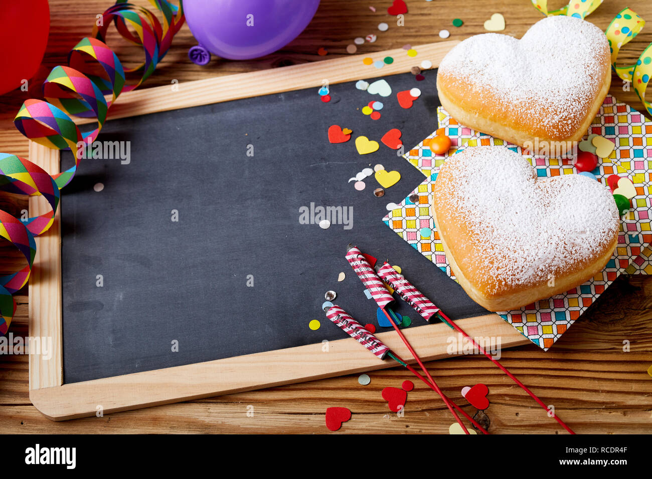 Ostern behandelt und Dekorationen mit Kopie Speicherplatz auf Tafel in Holzrahmen auf dem Tisch mit Herzförmigem Plätzchen, Konfetti, Böller, gesehen Stockfoto