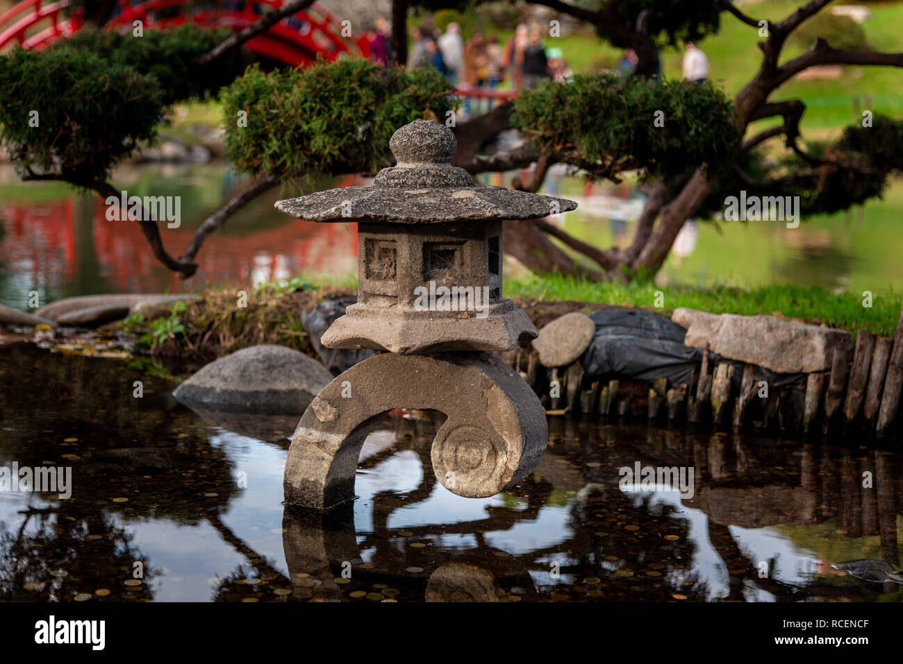 Münzen in einem kleinen japanischen Teich mit Reflexionen Stockfoto