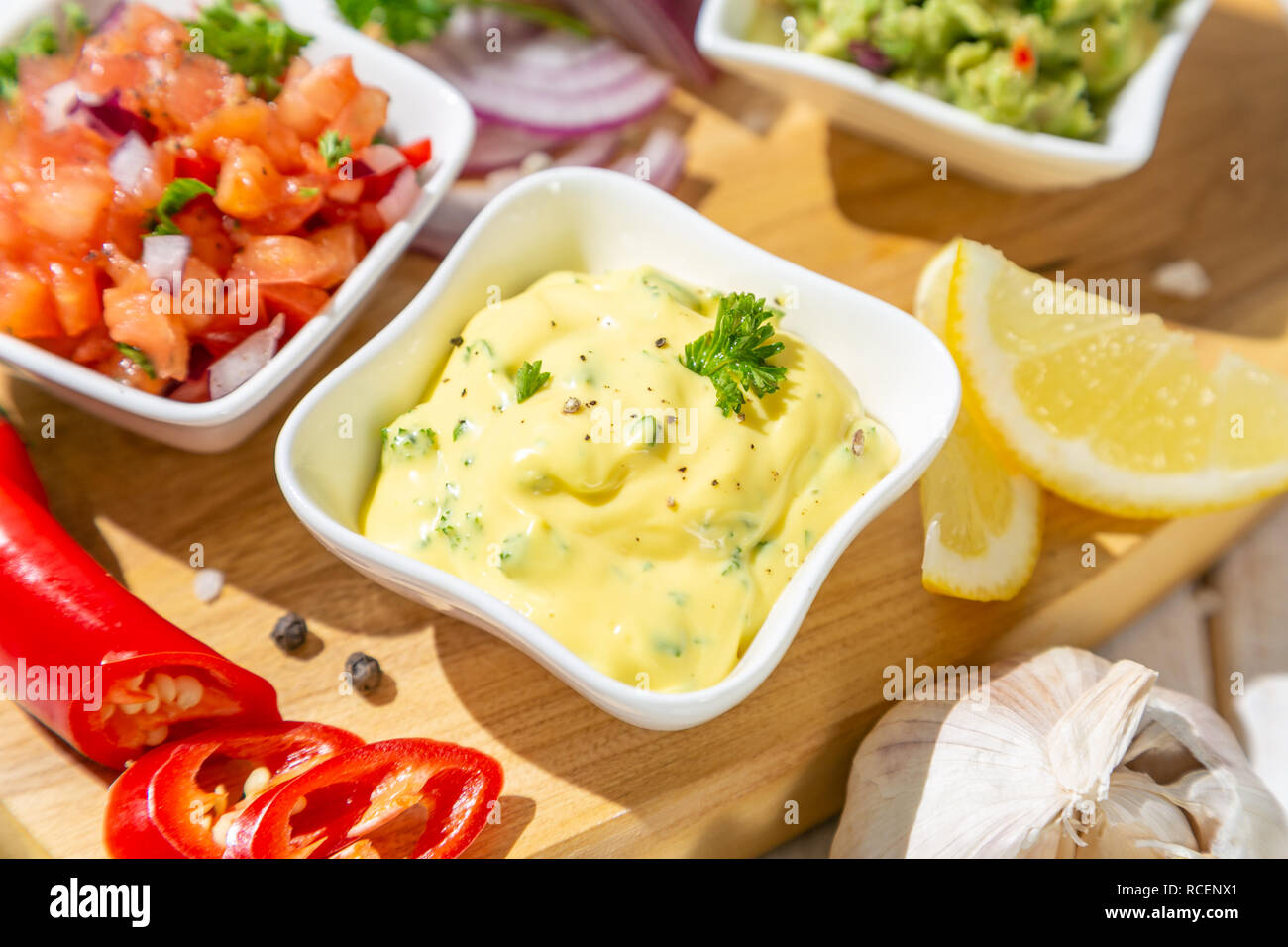 Auswahl an mexikanischen Soßen - Salsa, Guacamole, Käse Sauce und Zutaten, weiß Holz Hintergrund Stockfoto