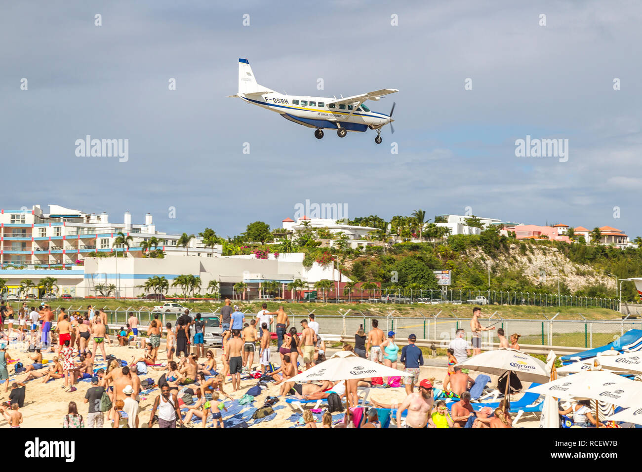 F-0 SBH St Barth Commuter, Cessna Grand Caravan (C208B) fliegen in niedrig über Moho Bay in Princess Juliana Flughafen in St. Marten. Stockfoto