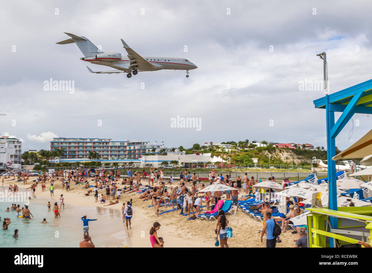 VistaJet, 9 H-VJK, Bombardier Global 6000 in niedrig über Moho Bay fliegen in Princess Juliana Flughafen in St. Marten. Stockfoto