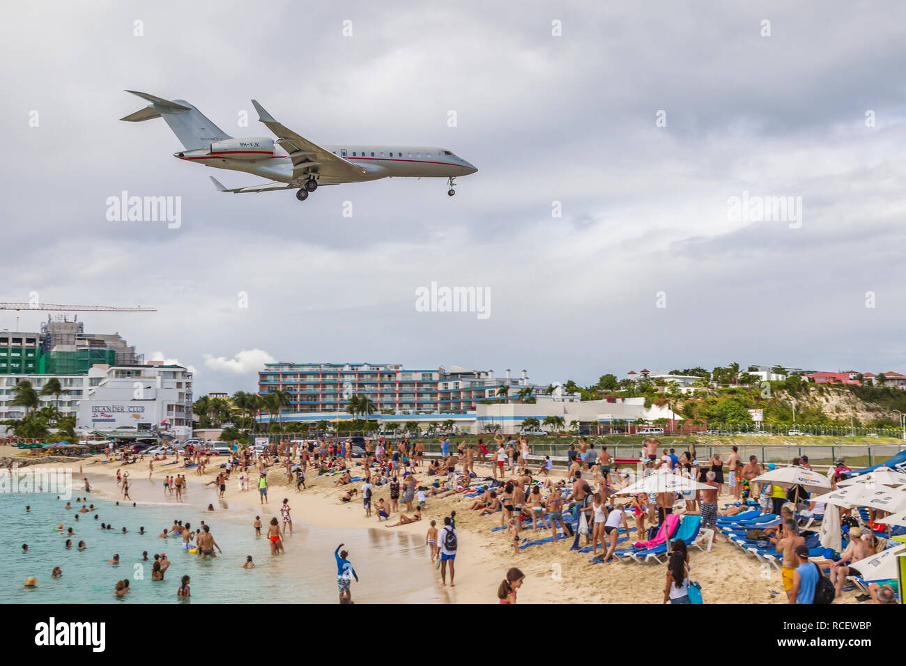 VistaJet, 9 H-VJK, Bombardier Global 6000 in niedrig über Moho Bay fliegen in Princess Juliana Flughafen in St. Marten. Stockfoto